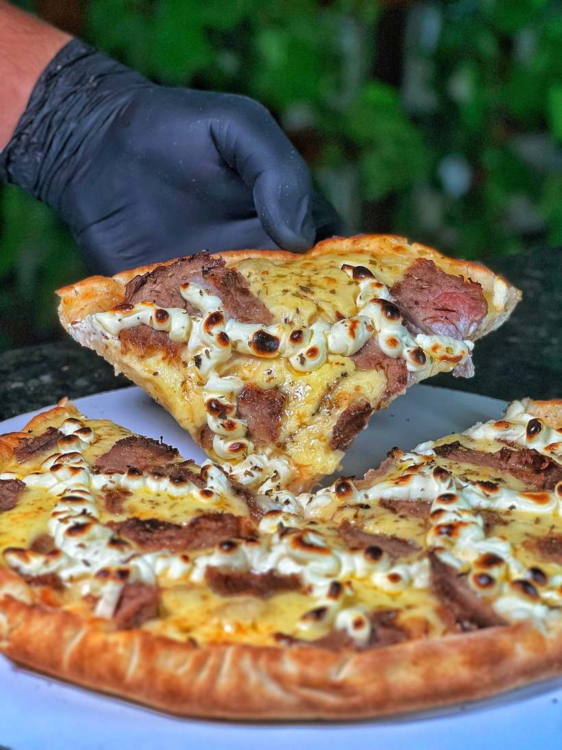 Fatia de pizza de picanha fatiada com queijo derretido